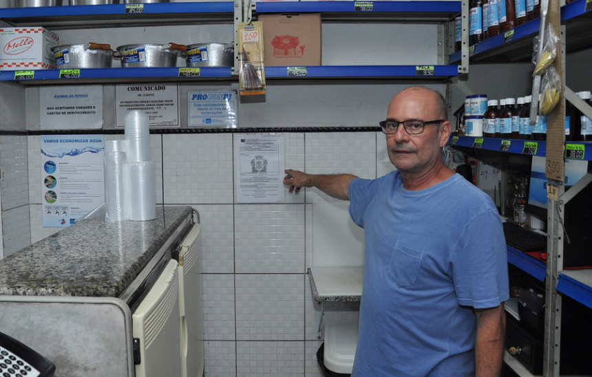 Luiz Carlos Marques, dono de mercearia no Centro, exibe na parede sua licença sanitária