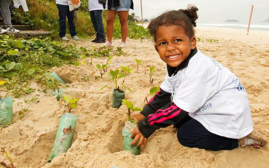 Criança planta muda de árvore na Barra da Tijuca