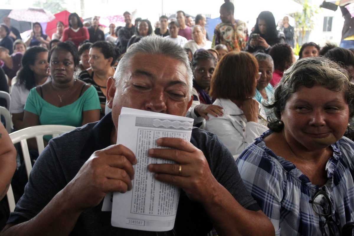Reginaldo, contemplado com o RGI, beija o documento: fim de um ciclo, e agora proprietário de fato do imóvel onde vive. Foto: Marcelo Piu / Prefeitura do Rio