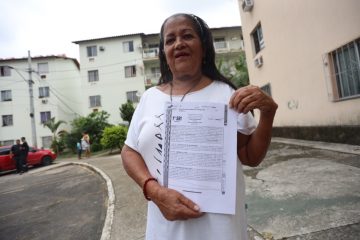 Dona Sandra exibe o documento de registro do imóvel onde vive no Mangueira I. Foto: Edvaldo Reis / Prefeitura do Rio