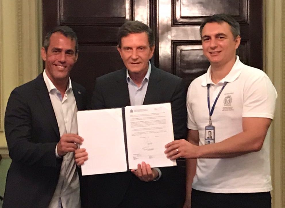 O prefeito Marcelo Crivella mostra o termo de cessão de terreno da Prefeitura ao governo do Estado, ao lado do vereador Marcelo Siciliano e do secretário estadual de Educação, Pedro Fernandes. Foto: Paula Seabra / Prefeitura do Rio