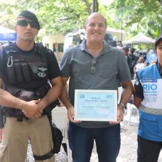 Morador de Copabana, Horácio, homenageado pelo Rio+Seguro, faz pose ao lado do GM Gomes e da PM Lilian. Foto: Edvaldo Reis / Prefeitura do Rio