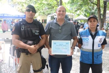 Morador de Copabana, Horácio, homenageado pelo Rio+Seguro, faz pose ao lado do GM Gomes e da PM Lilian. Foto: Edvaldo Reis / Prefeitura do Rio