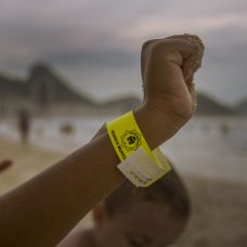 Criança mostra pulseirinha de identificação distribuída pela Guarda Municipal.